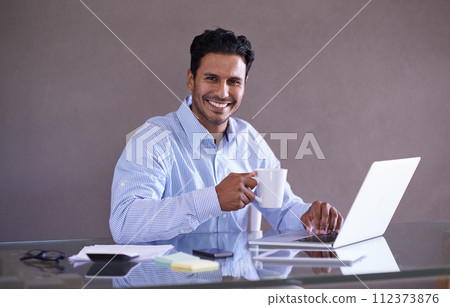 Businessman, laptop and portrait by desk for coffee, relax and social media with browse for online research. Entrepreneur, smile face and technology at work, wellness and tea break in startup company Businessman, laptop and portrait by desk for coffee, relax and social media with browse for online research. Entrepreneur, smile face and technology at work, wellness and tea break in startup company 112373876
