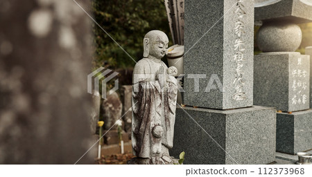 Buddha, statue and tombstone in graveyard with culture for safety, protection and sculpture outdoor in nature. Jizo, Japan and memorial gravestone with history, tradition and monument for sightseeing Buddha, statue and tombstone in graveyard with culture for safety, protection and sculpture outdoor in nature. Jizo, Japan and memorial gravestone with history, tradition and monument for sightseeing 112373968