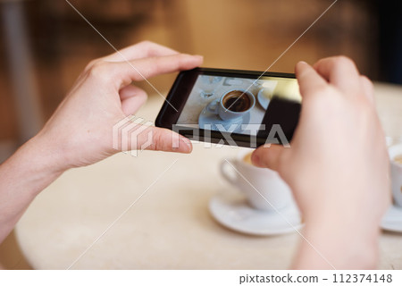 Cellphone, hands and photography of coffee in restaurant and online to review a cappuccino. Person, mobile app and post of espresso for social media followers and influencer with drink in close up 112374148