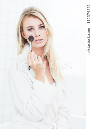 Woman, portrait and blonde with makeup brush for cosmetics or facial treatment in bathroom at home. Face of attractive young female person or model applying foundation or skincare on mockup space Woman, portrait and blonde with makeup brush for cosmetics or facial treatment in bathroom at home. Face of attractive young female person or model applying foundation or skincare on mockup space 112374261