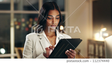 Night, tablet and business woman typing, scroll and manager review journalist story, social media blog and working late. Professional news reporter, reading and Indian person check online article 112374440