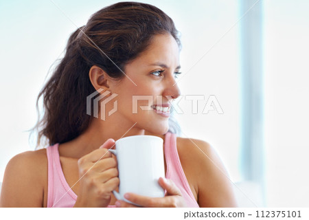 Thinking, smile and woman drinking coffee in home, espresso or latte for breakfast to relax in living room in the morning. Dream, tea cup and happy person or girl with healthy beverage in apartment 112375101
