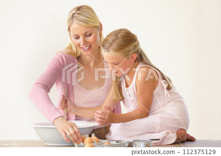 Eggs, baking and happy mom, child or family make dessert, food or prepare recipe, wheat flour or ingredients. Kitchen, bowl and young kid girl learning home cooking together for Mothers Day bonding 112375129