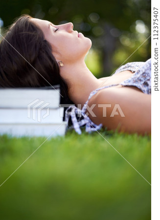 Books, grass and woman on campus relax, calm and resting for studying, class and learning. Education, university and person outdoors for wellness, fresh air and peace with textbooks for knowledge 112375407