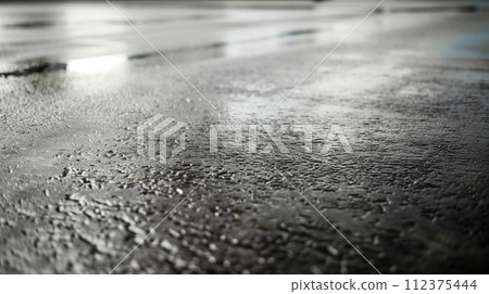 Advertising shot of perfect withour cracks wet black asphalt road texture covered with puddles highlighted with light from the side 112375444