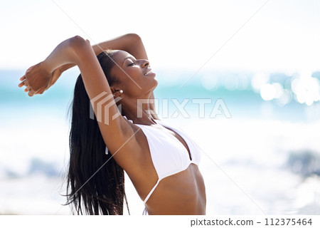 Black woman on beach, relax and smile on holiday with waves, sunshine and tropical island travel. Sea, mountain and happy girl on ocean vacation in summer with adventure, peace and blue sky horizon. Black woman on beach, relax and smile on holiday with waves, sunshine and tropical island travel. Sea, mountain and happy girl on ocean vacation in summer with adventure, peace and blue sky horizon. 112375464