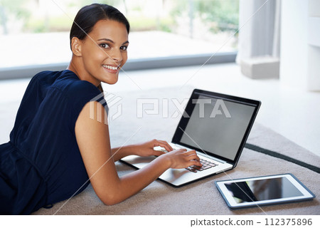 Laptop, smile and portrait of woman relaxing on carpet working on freelance project at home. Happy, technology and female person with computer for creative research laying on floor mat in living room 112375896