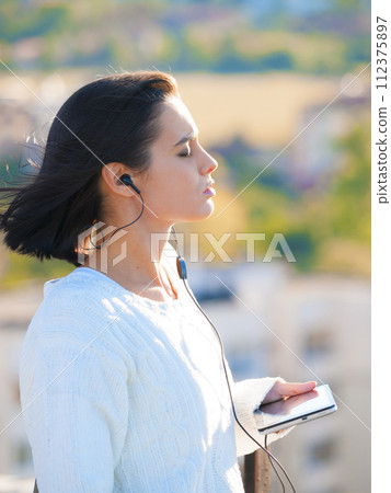 Woman, city and earphones with tablet, podcast or music for listening or relaxing while thinking. Worker, technology and mental health with audio, mindfulness and media for wellness and ideas or zen 112375897