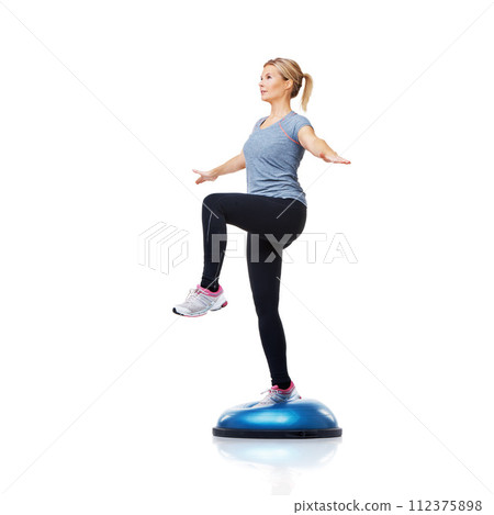 Woman, bosu ball or leg balance in workout for development isolated on white background. Female athlete, training equipment or fitness for studio mockup space, body challenge or exercise for wellness 112375898