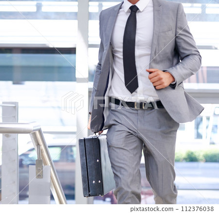 Businessman, suitcase and walking with fashion for travel, immigration or rushing to office. Closeup of man or employee in stylish suit with briefcase in a hurry for business opportunity or traveling Businessman, suitcase and walking with fashion for travel, immigration or rushing to office. Closeup of man or employee in stylish suit with briefcase in a hurry for business opportunity or traveling 112376038