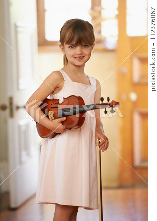 Violin, girl and portrait of happy kid in home for learning, practice and music education. Art, fiddle and student with bow for talent, creative or hobby with acoustic string instrument in Canada Violin, girl and portrait of happy kid in home for learning, practice and music education. Art, fiddle and student with bow for talent, creative or hobby with acoustic string instrument in Canada 112376067