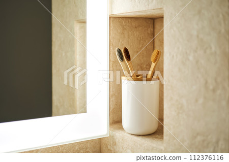 Natural bamboo toothbrushes in a glass in the bathroom. 112376116