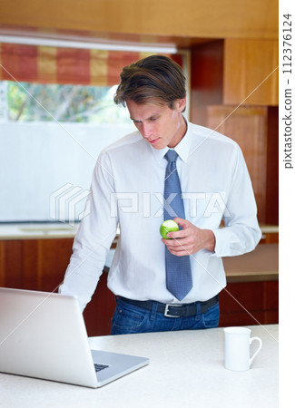 Laptop, fruit and business man in kitchen for morning routine, remote working and healthy breakfast. Professional, worker and person on computer for website, research and internet in home with apple Laptop, fruit and business man in kitchen for morning routine, remote working and healthy breakfast. Professional, worker and person on computer for website, research and internet in home with apple 112376124