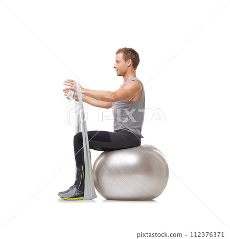Yoga ball, resistance band and man doing workout in studio for health, wellness and bodycare. Sport, fitness and young male person from Australia with arms exercise or training by white background. 112376371