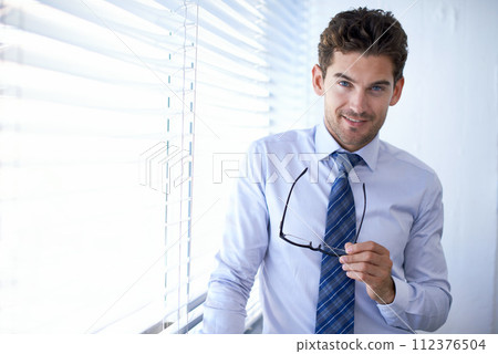 Businessman, portrait and smile for office, glasses and in professional workspace. Male person, smart and confident for ambition, startup and entrepreneur for career and corporate project expert 112376504