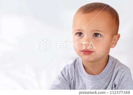 Thinking, cute and boy baby on bed in the nursery of modern home relaxing and sitting. Calm, mockup and serious young kid, infant or toddler with child development for growth in bedroom at house. 112377169