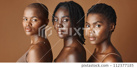 Beauty, face or black women models with glowing skin or afro isolated on brown background. Facial dermatology, diversity or skincare cosmetics for makeup in studio with girl friends or African people Beauty, face or black women models with glowing skin or afro isolated on brown background. Facial dermatology, diversity or skincare cosmetics for makeup in studio with girl friends or African people 112377185