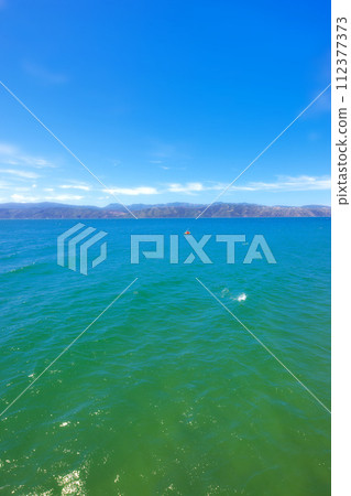 Blue sky, nature and drone of ocean on island for travel, vacation or holiday with skyline and seascape. Outdoor, water and aerial view of sea by tropical beach for scenic summer weekend trip. Blue sky, nature and drone of ocean on island for travel, vacation or holiday with skyline and seascape. Outdoor, water and aerial view of sea by tropical beach for scenic summer weekend trip. 112377373