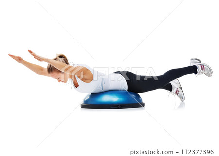 Fitness, bosu ball and woman in a studio for stretching body workout or training with balance. Sports, equipment and young female person with muscle warm up exercise isolated by white background. 112377396