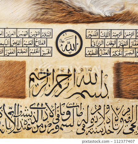 Islamic calligraphy characters on skin leather with a hand made calligraphy pen, the names of Allah (God) are written in arabic 112377407