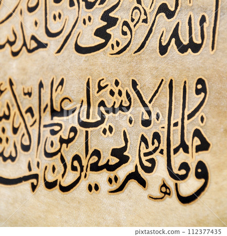 Islamic calligraphy characters on skin leather with a hand made calligraphy pen, the names of Allah (God) are written in arabic 112377435