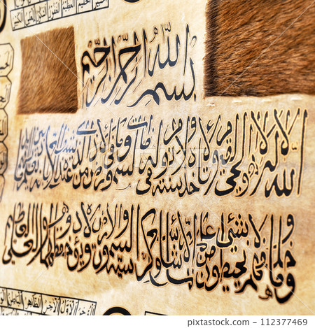Islamic calligraphy characters on skin leather with a hand made calligraphy pen, the names of Allah (God) are written in arabic Islamic calligraphy characters on skin leather with a hand made calligraphy pen, the names of Allah (God) are written in arabic 112377469