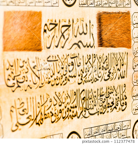 Islamic calligraphy characters on skin leather with a hand made calligraphy pen, the names of Allah (God) are written in arabic 112377478