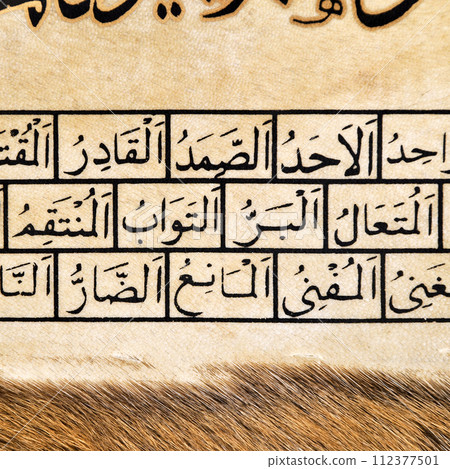 Islamic calligraphy characters on skin leather with a hand made calligraphy pen, the names of Allah (God) are written in arabic 112377501