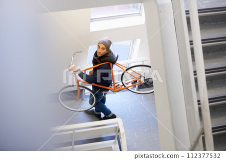 Bicycle, stairs and man in a building carrying bike for healthy and eco friendly transportation for travel. Staircase, carry and cyclist with apartment complex, take up and journey of walking steps 112377532