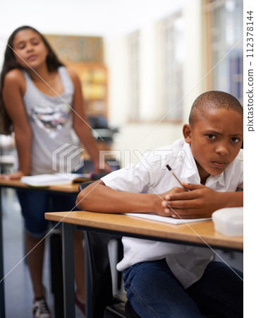 Portrait, copy or students cheating in exam with paper, school corruption or education fraud. Cover, girl peeking or smart male child learner hiding or writing answers in test in classroom at desk 112378144