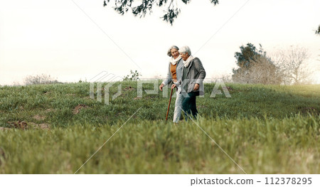 Senior woman, friends and walking in park in outdoor for quality time or to relax in environment. Retirement, support and conversation with elderly female person together in nature for bond or care, Senior woman, friends and walking in park in outdoor for quality time or to relax in environment. Retirement, support and conversation with elderly female person together in nature for bond or care, 112378295
