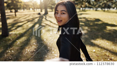 Japanese woman, pov and hand on walk, portrait and smile in park to show path, nature and trees. Girl, person and outdoor with grass, lawn and plants for freedom, adventure or travel journey in Tokyo 112378630