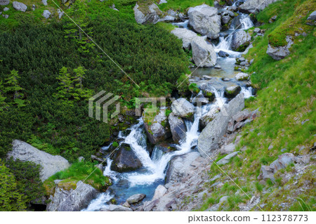 mountain waterstream among the rocks on the hillside. view from above. beauty of carpathian nature mountain waterstream among the rocks on the hillside. view from above. beauty of carpathian nature 112378773