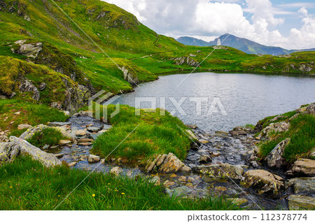 capra lake of fagaras range on a cloudy day. summer nature background in mountain of romania. popular travel destination of transylvania alps capra lake of fagaras range on a cloudy day. summer nature background in mountain of romania. popular travel destination of transylvania alps 112378774
