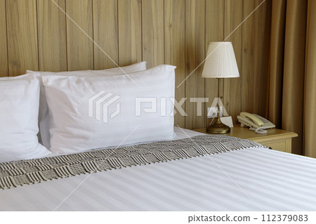 Luxurious Bedroom with Comfortable Bed, Stylish Furniture, and Soft Pillows in a Cozy Home Setting 112379083