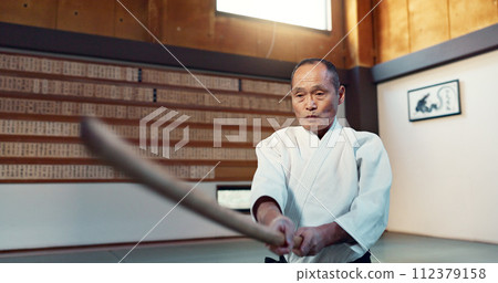 Aikido sword, martial arts and mature man strike for training, self defense or combat technique. Dojo, Japanese person and expert with wooden weapon for skills development, attack or bokken practice Aikido sword, martial arts and mature man strike for training, self defense or combat technique. Dojo, Japanese person and expert with wooden weapon for skills development, attack or bokken practice 112379158