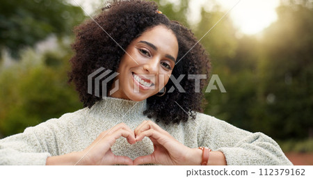 Face, smile and woman with heart hands, outdoor and support with emoji, kindness and wellness. Portrait, female person or happy girl with symbol for love, self care or peace with trust, park and care 112379162