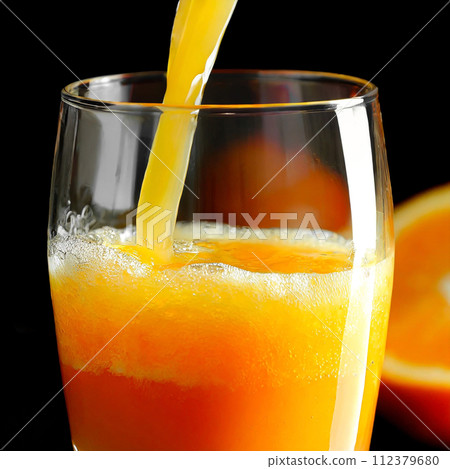 將鮮榨柳橙汁倒入玻璃杯中 112379680