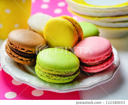 Assortment of colorful macarons arranged on a retro and pop cloth 112380033