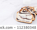 Fresh sweet tasty yeast baked goods with poppy seed filling on white plate at white background. Delicious homemade bun 112380348
