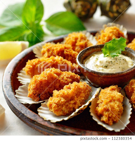 Lots of fried oysters and tartar sauce 112380354