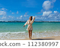Beautiful young woman is happy by the sea 112380997