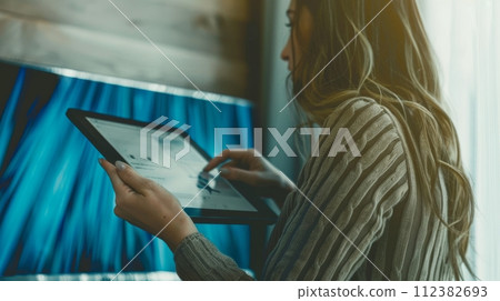 AI-generated content. A young professional woman executive or manager in a modern corporate environment holding a digital tablet using a pad technology device. 112382693