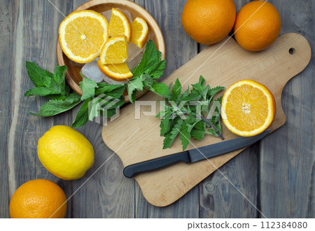 Delicious orange lemonade with soda water and mint on old wood table, space for text. cocktail. Delicious orange lemonade with soda water and mint on old wood table, space for text. cocktail. 112384080