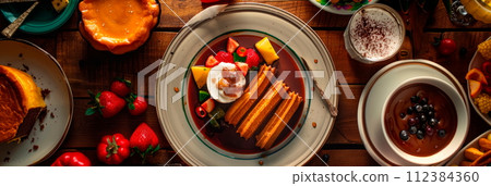 Mexican desserts, including churros, flan, and tres leches cake. 112384360