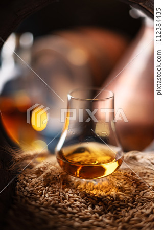 A glass of whiskey in oak barrel 112384435