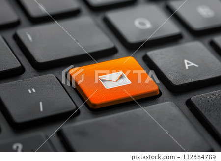 Close-up of a keyboard with an orange email icon key. Email marketing or newsletter concept 112384789