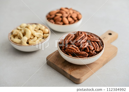 Pecan nuts, almond and cashew in bowls Pecan nuts, almond and cashew in bowls 112384992