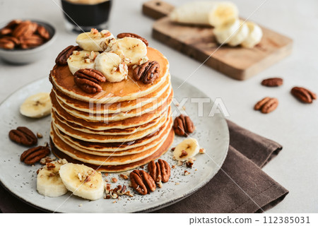 Plate of maple pecan pancakes with fresh bananas 112385031