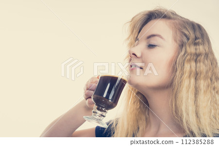 Positive woman drinking her morning coffee Positive woman drinking her morning coffee 112385288